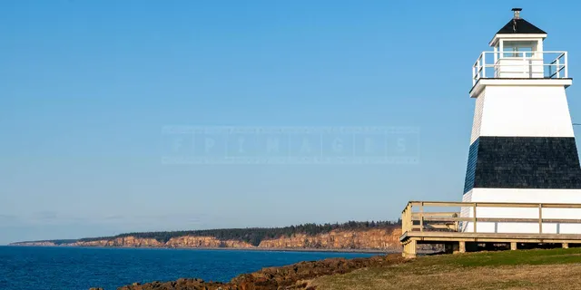 Seaside landscape with black and white lighthouse