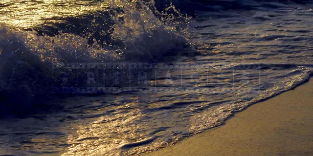 waves rolling onto the beach at sunset