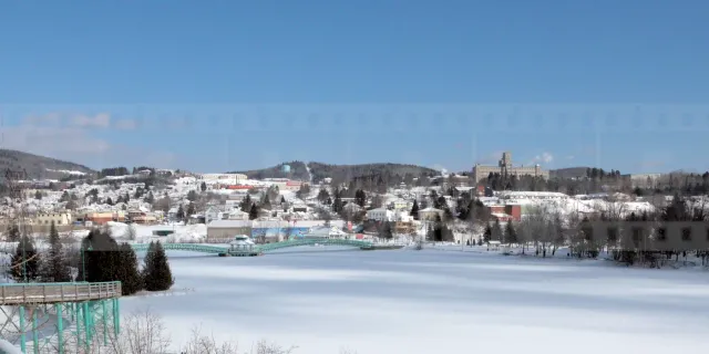 Frozen lake and snow-covered winter cityscape of Edmundston in Canada