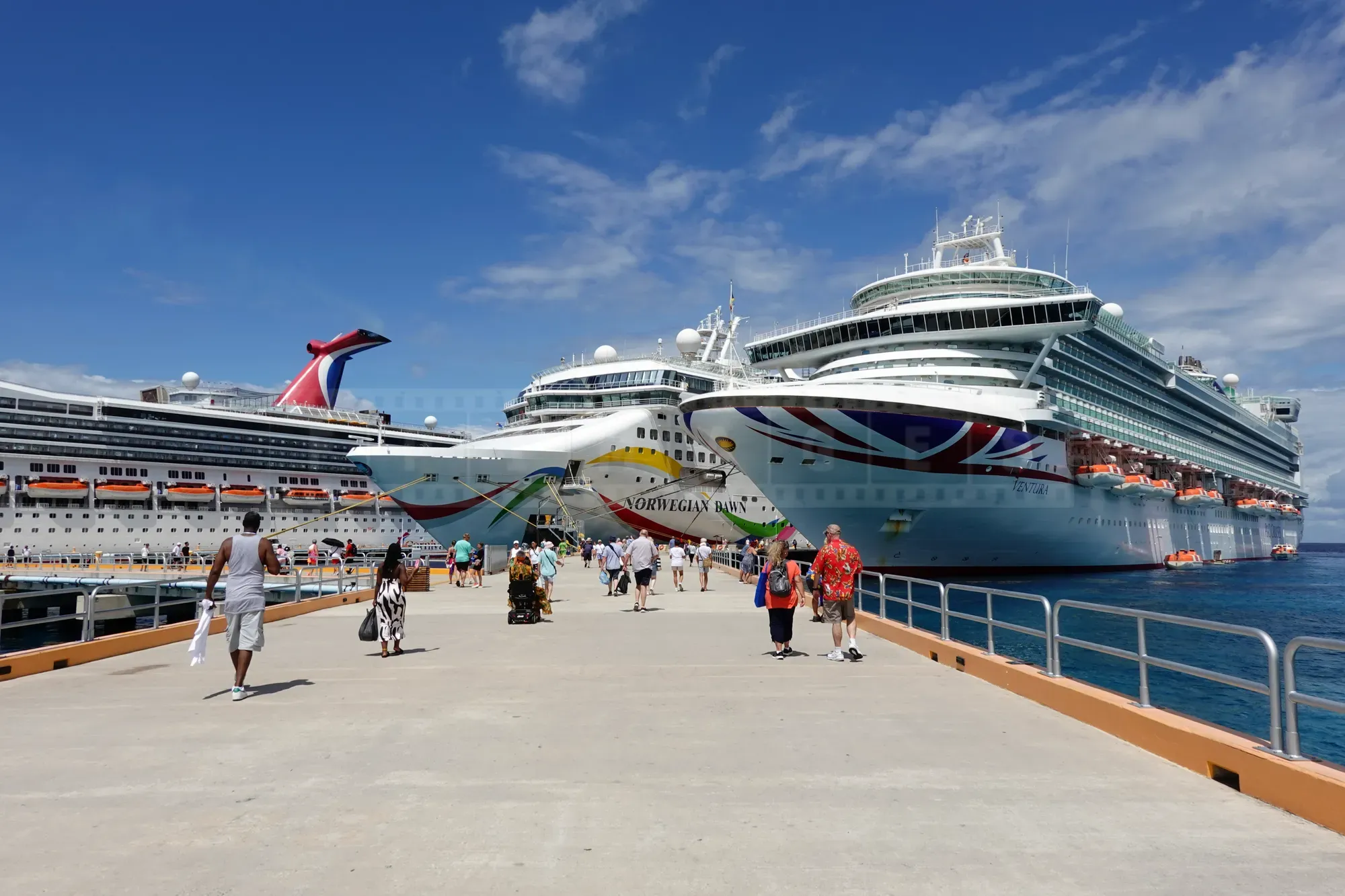 Three large cruise ships docked side by side at a sunny port in Mexico.