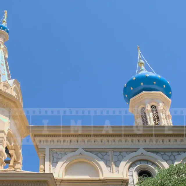 Pretty bell tower with small dome and a larger blue dome with golden stars