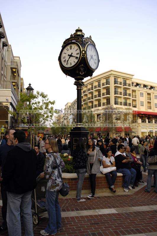 People sitting and Conversing near the Clock Post