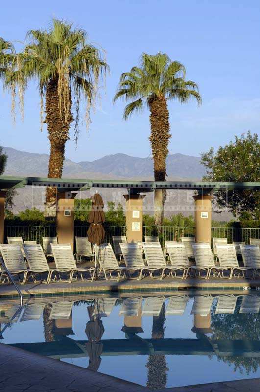 Image of the Lounge Chairs Reflecting in the Pool Waters