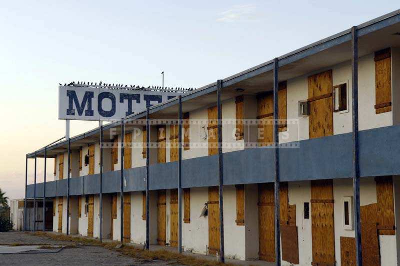 Boarded up motel doors and windows