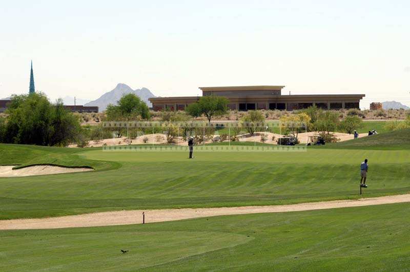 Golfers near the green chipping and putting