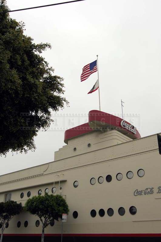 Vertical view of the red coca cola sign and factory building