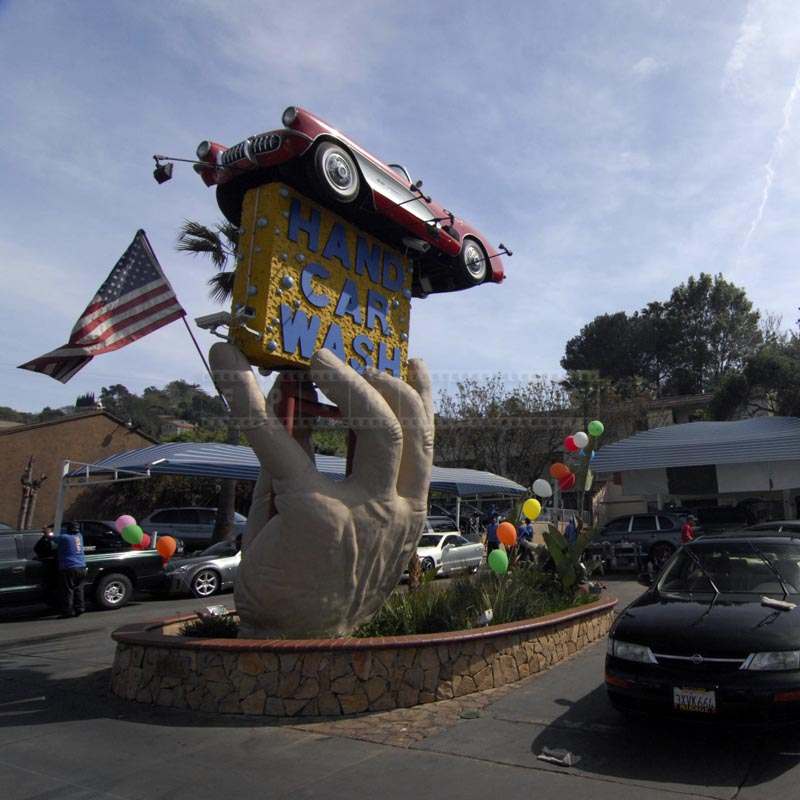 A Giant Hand Holding a Signboard and Car