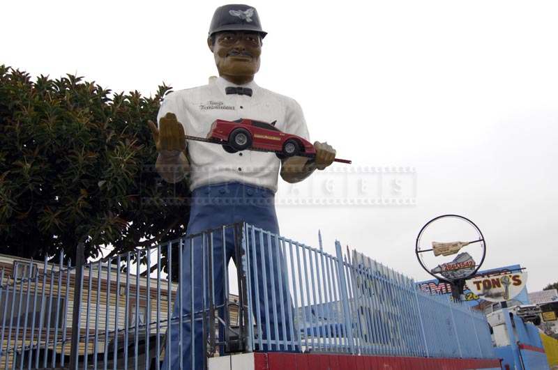 Tony The Muffler Man Holding a Car