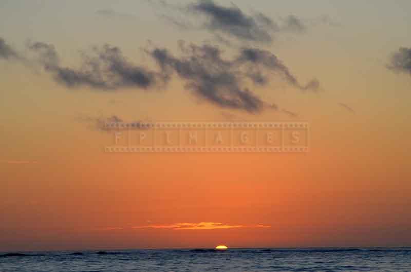 Clear horizon line and the sun appearing above it at sunrise