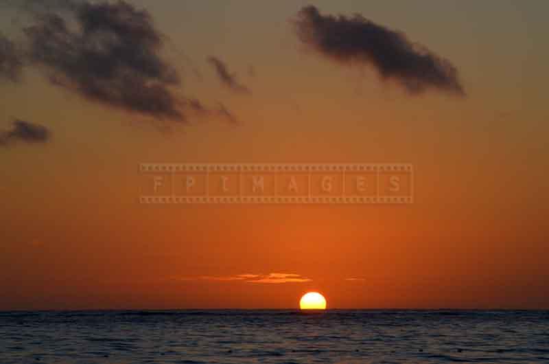 Clear horizon line and the sun appearing above it at sunrise