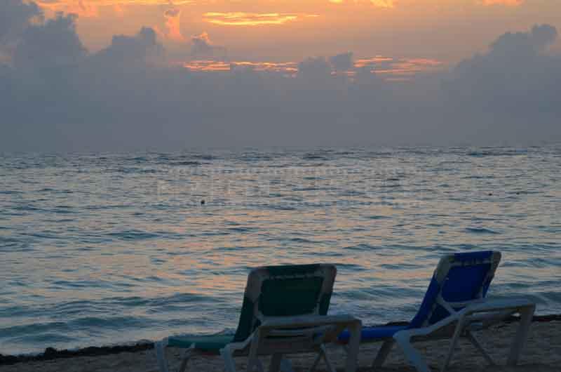 Beach chairs facing sunrise