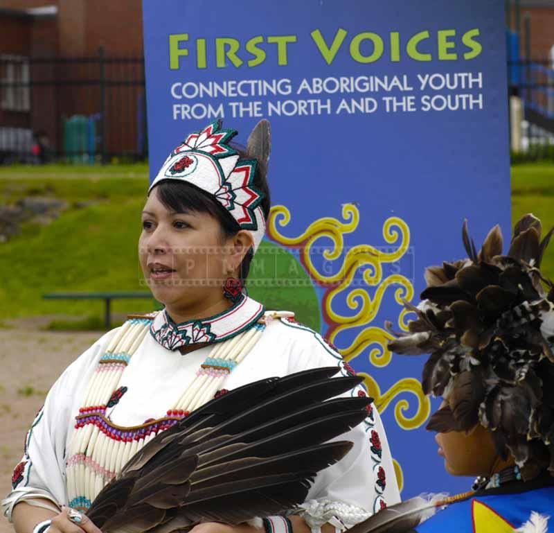 A woman in a native dress with a dark feather fan