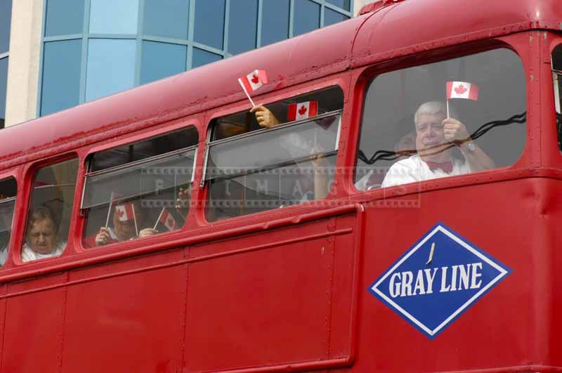 People with Canadian flags in double Decker bus