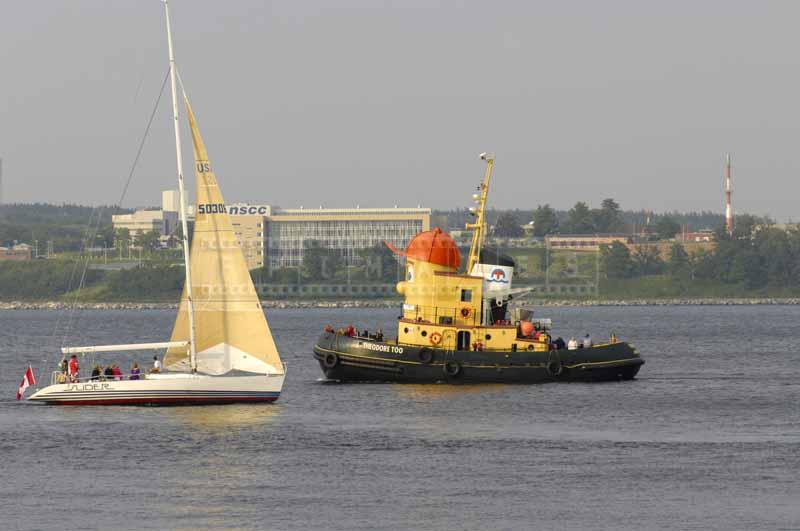 Theodore tug boat and a yacht in the harbor