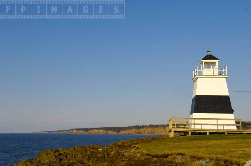 Seaside landscape with black and white lighthouse