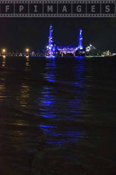 Pirate ship and blue lights refelcting in the ocean