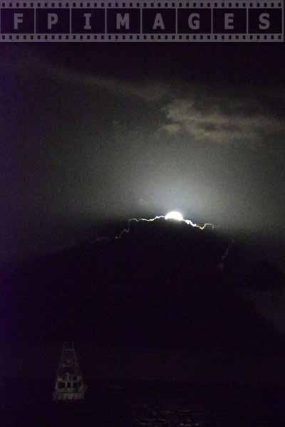 Full moon rising above clouds