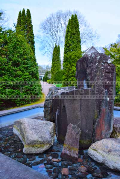 Nova Scotia rocks used to create rock fountain, cypress trees image