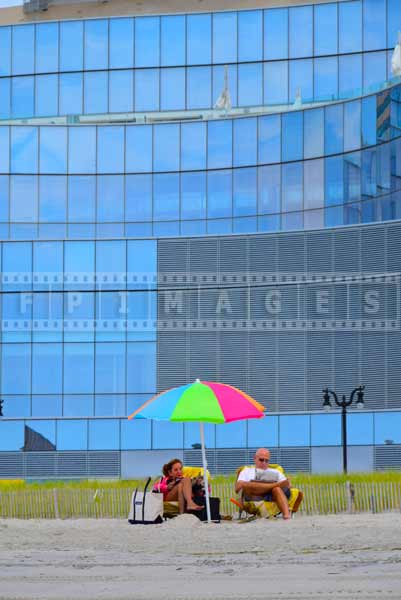 Couple under brightly colored beach umbrella