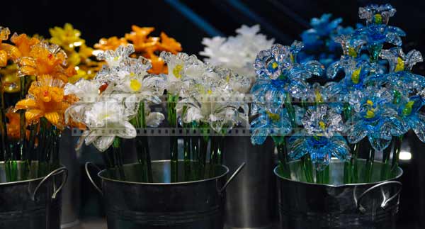 Orange, white and blue glass flowers for sale at the glass market, travel images