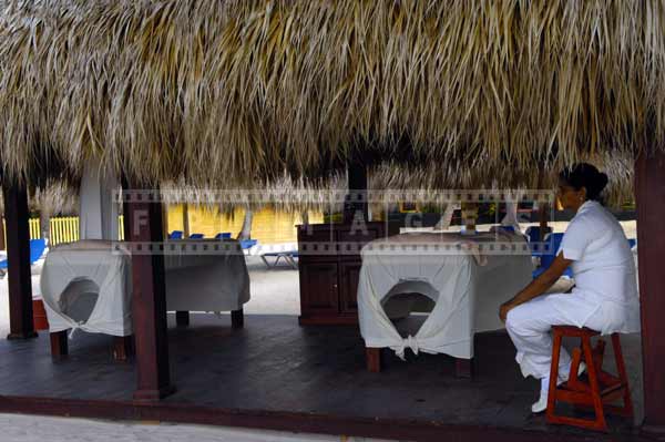 Palapa shelter with thatched roof used as a beachfront massage parlor