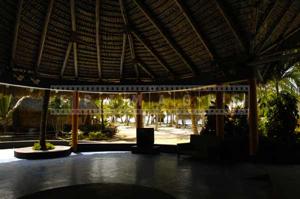 Large gazebo with a thatched roof dome providing shelter from tropical sun, architectural photography