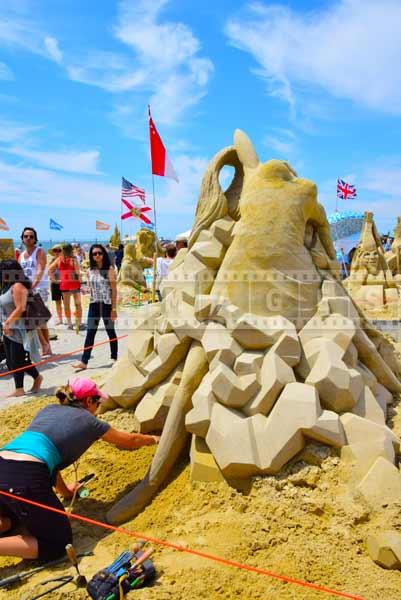 People looking at Canadian sand sculptor Melineige Beauregard