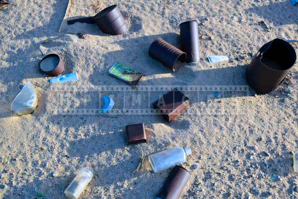 Pattern of old rusty tin cans on the desert sand, abstract art photography