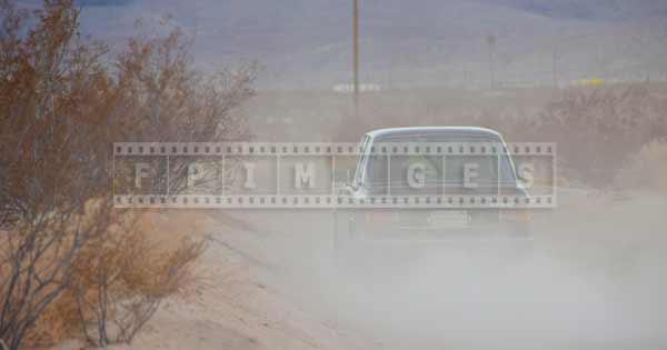 Dust behind the classic car on a dirt road, car images