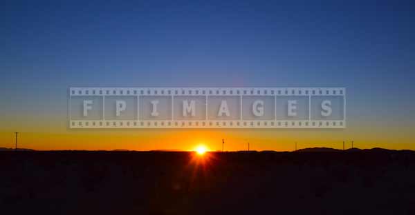 First rays of sun above desert horizon