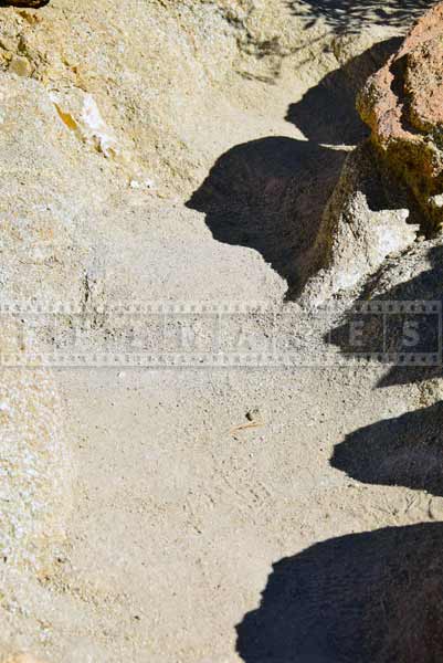 Sand and small rocks cover the trail, hiking trail detail photo