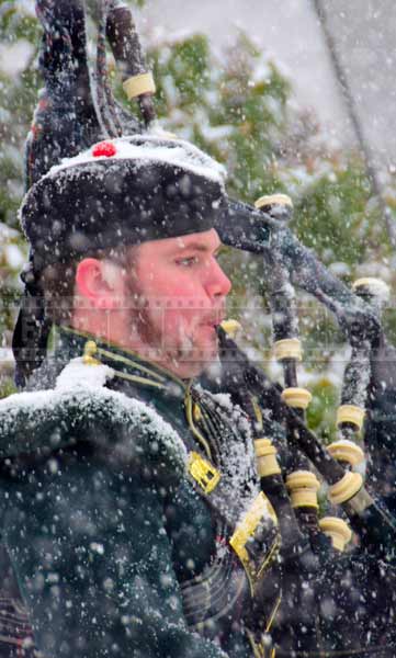 Close up portrait of a bagpipe player in heavy snow