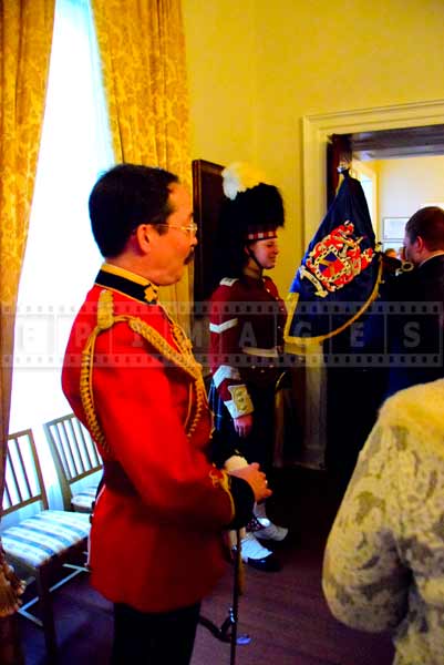 Canadian officer in red uniform looking at people passing by