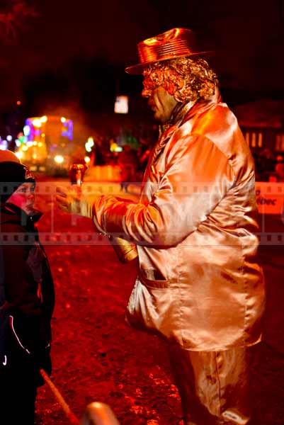 Clown dressed in gold shows a trick to kids