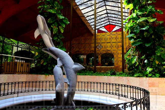 Dolphin sculpture and wrought iron decorations at hotel entrance