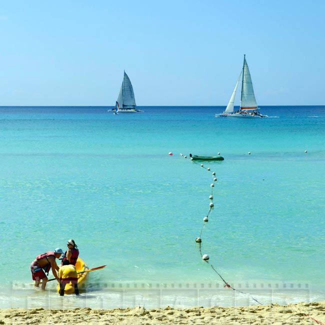 Couple preparing to paddle kayak at the beach