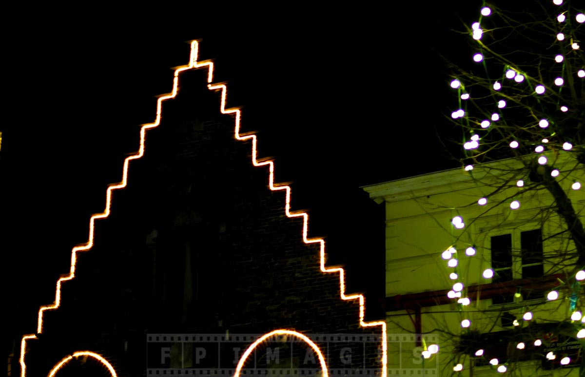 Old building roof decorations at night in Bruges