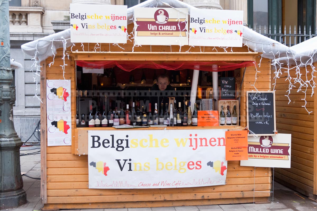 a wooden booth selling Belgian wines by the bottle and hot wine by the glass