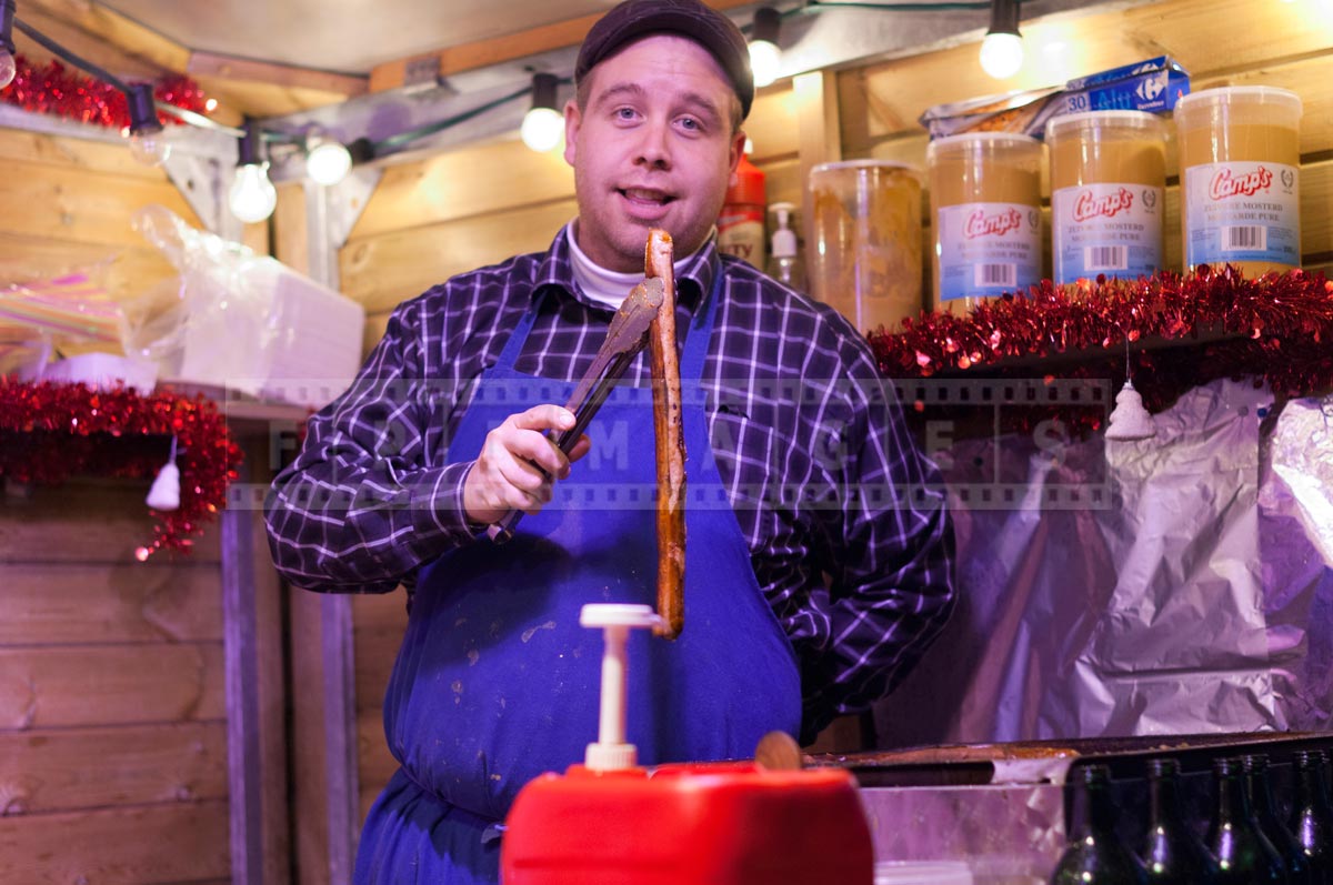 man showing grilled Belgian sausage