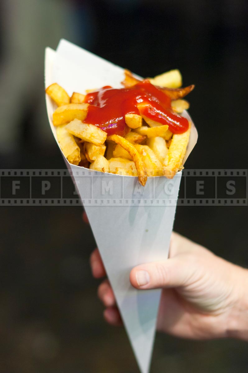 Belgian fries with ketchup in a paper cone