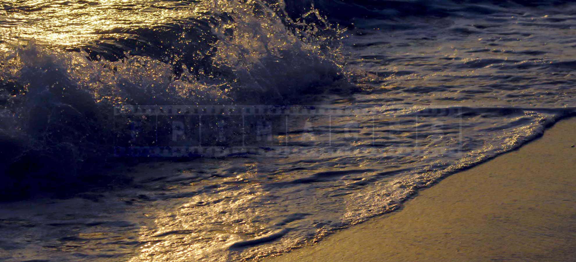 waves rolling onto the beach at sunset