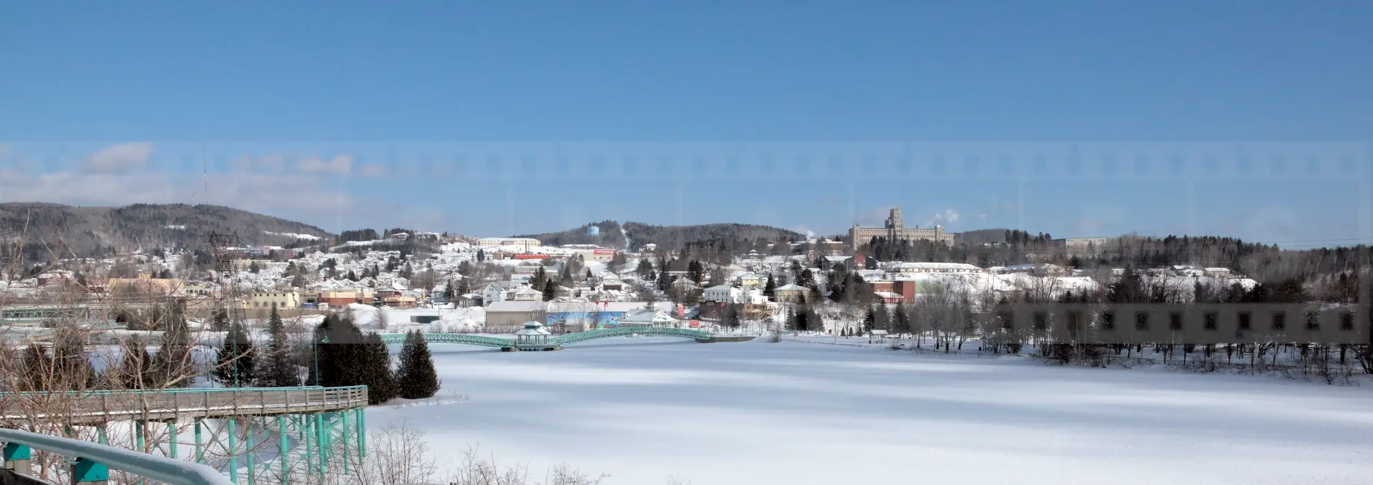 Frozen lake and snow-covered winter cityscape of Edmundston in Canada