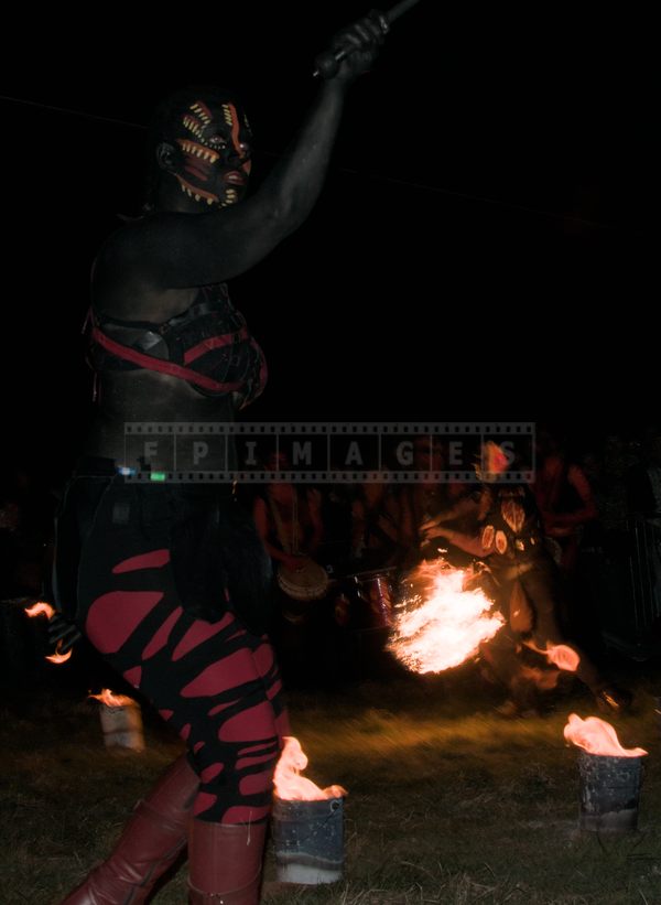 fire dancer with Polynesian make up and fire knife