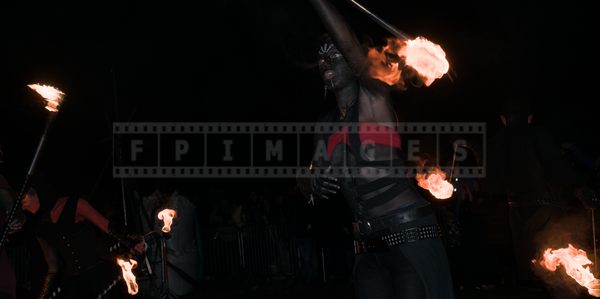 Artists with black painted skin are manipulating fire props