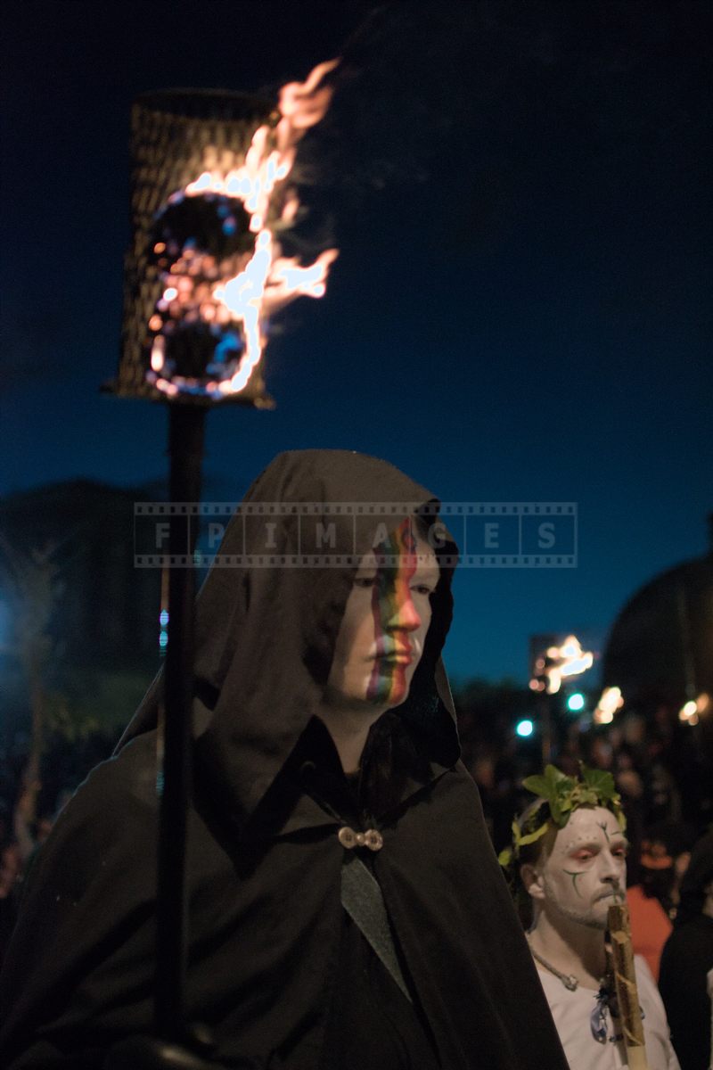 Man with a torch in a black cape at the Beltane fire ritual, Calton Hill, Edinburgh