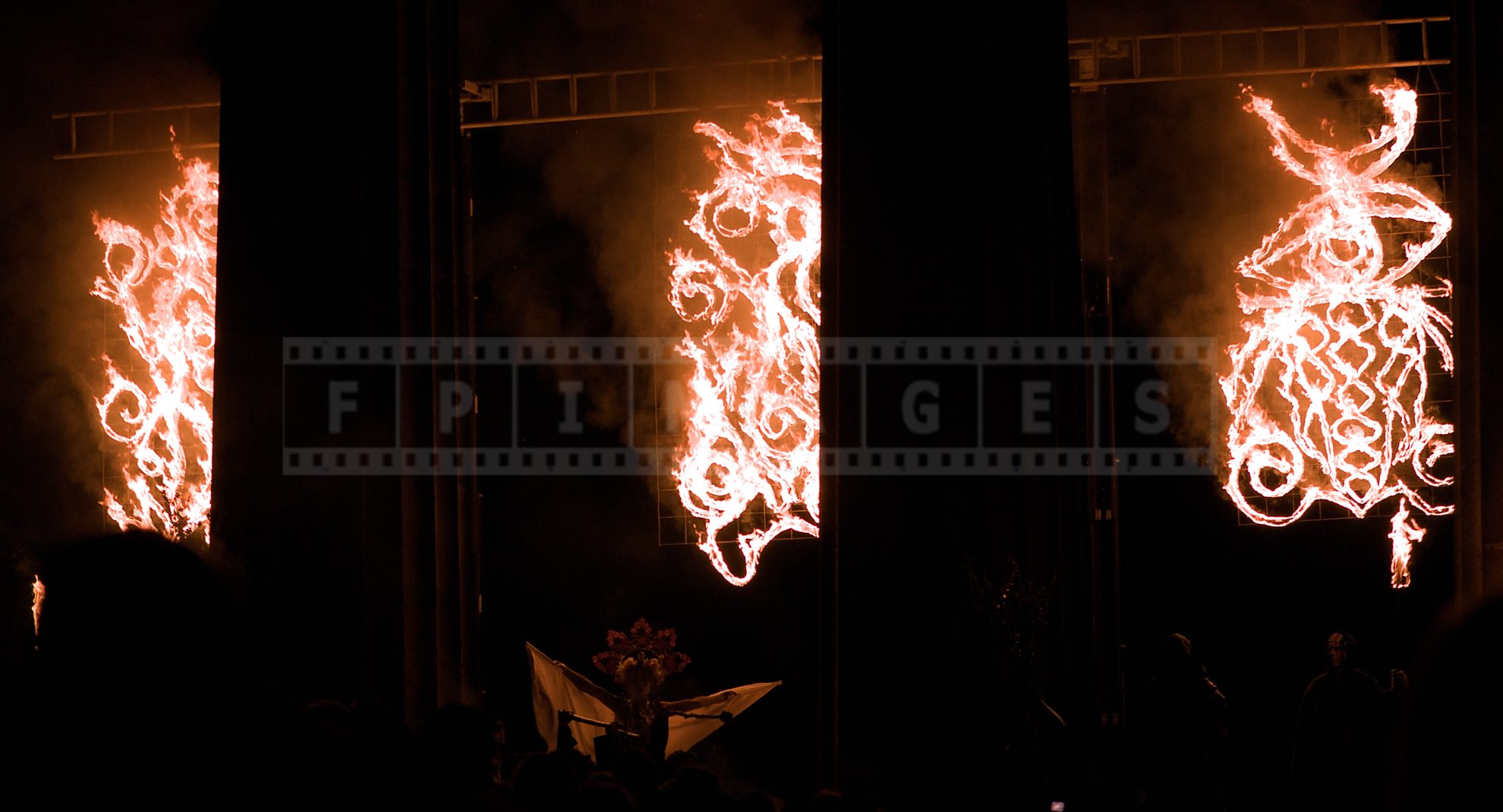 May Queen spreading her arms under the flames at the very start of the festival