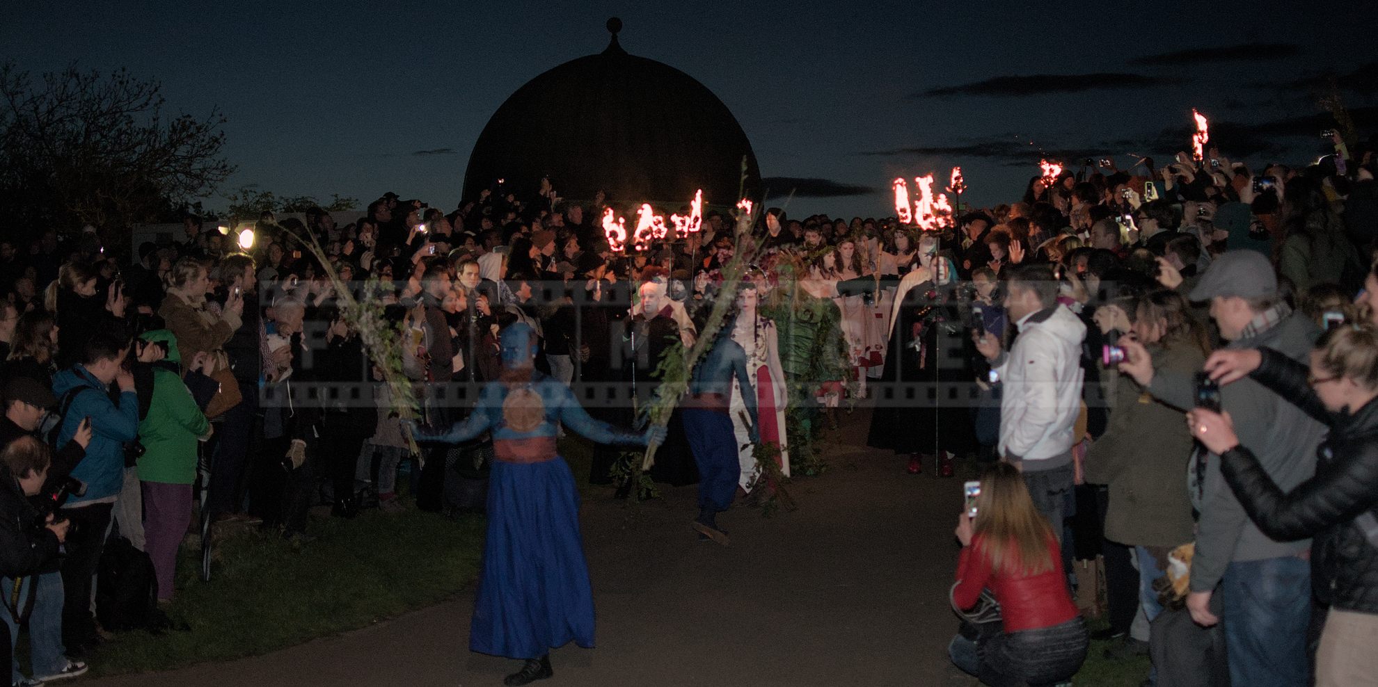 May Queen and Green Man lead the procession followed by the characters with torches