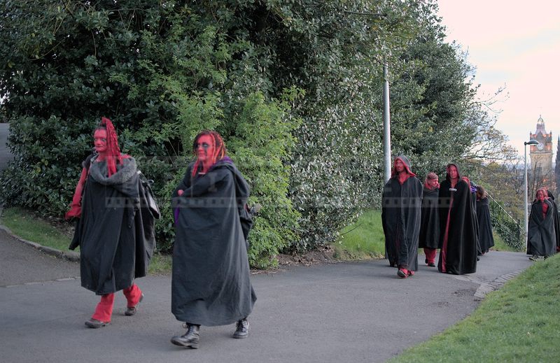 Beltane Fire fest crew with red hair and faces and black capes